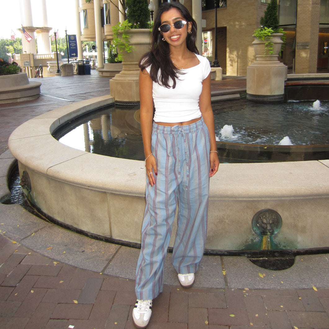 Woman standing in front of a fountain on a city street