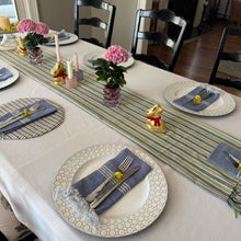 Load image into Gallery viewer, Dining table set with plates, napkins, and decorative items in a home setting.